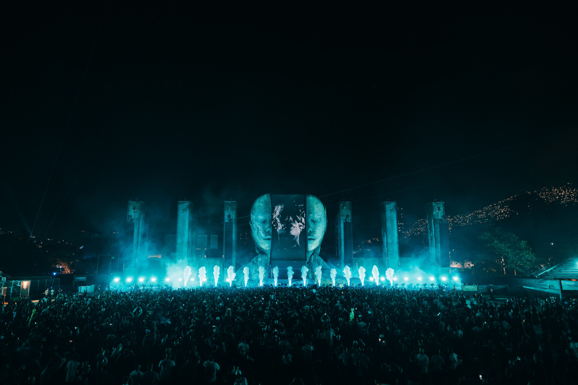 CORE stage lit teal with flame columns and crowd at night